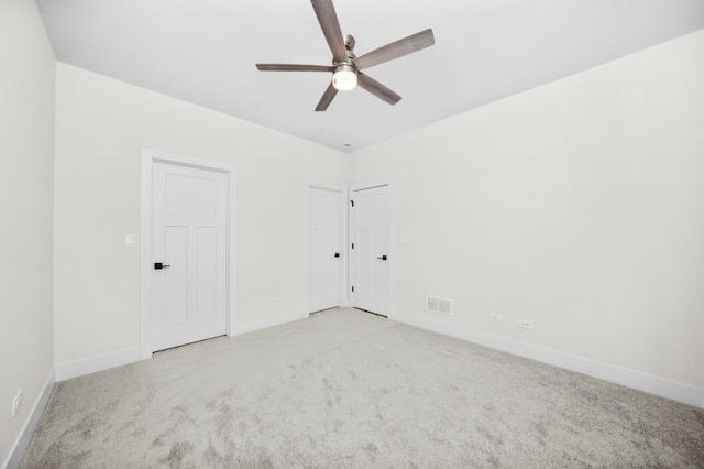 unfurnished bedroom featuring baseboards, visible vents, and carpet