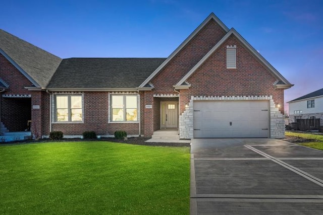 view of front facade featuring brick siding, driveway, roof with shingles, and a front lawn
