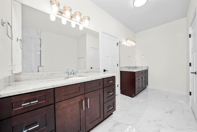 bathroom featuring baseboards, two vanities, a sink, and marble finish floor