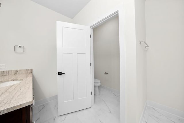 bathroom featuring toilet, baseboards, marble finish floor, and vanity