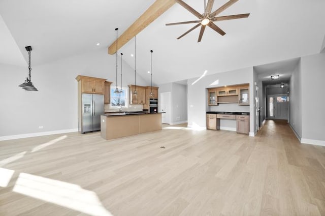 kitchen featuring dark countertops, baseboards, stainless steel appliances, and open floor plan