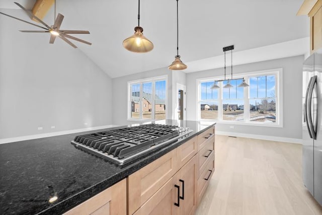 kitchen with light brown cabinets, stainless steel appliances, a ceiling fan, lofted ceiling, and pendant lighting