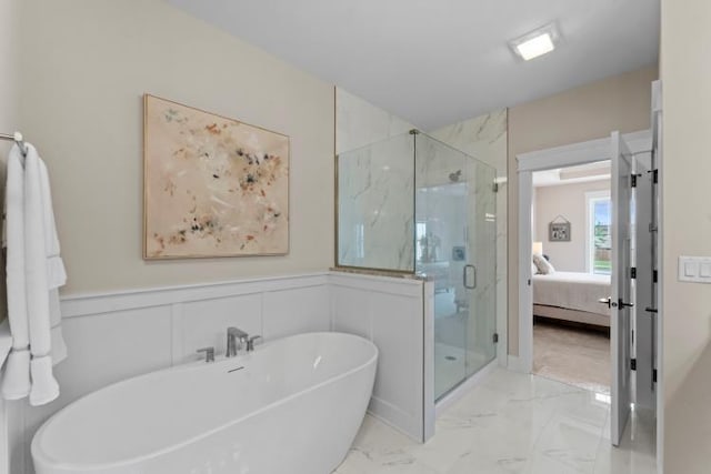 ensuite bathroom with connected bathroom, marble finish floor, a freestanding bath, and a marble finish shower