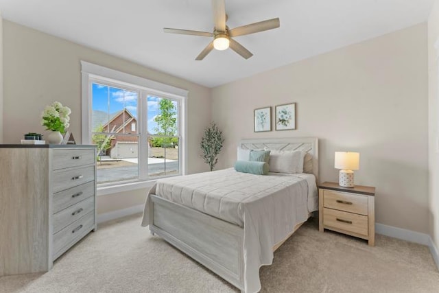 bedroom featuring baseboards, a ceiling fan, and light colored carpet