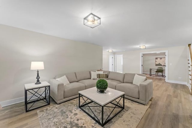 living room with baseboards and light wood-style flooring