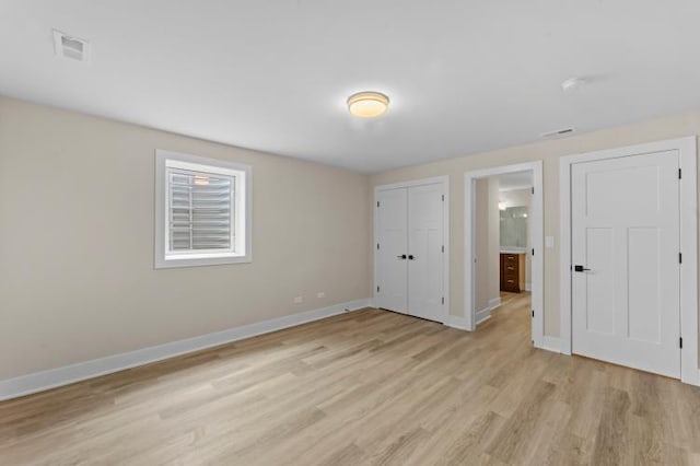 unfurnished bedroom featuring light wood-type flooring, baseboards, and visible vents