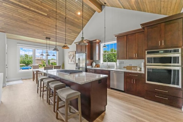 kitchen featuring light wood-style floors, wood ceiling, appliances with stainless steel finishes, and a kitchen island