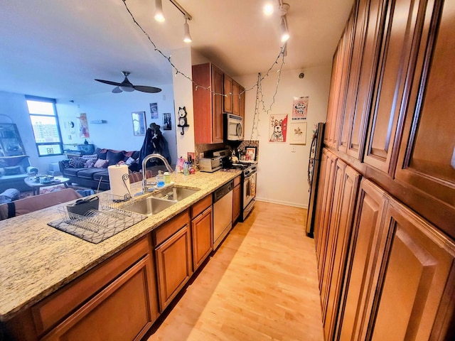 1255 S State St Unit 906, Chicago, IL 60605 - kitchen with brown cabinets, a sink, open floor plan, appliances with stainless steel finishes, and light stone counters