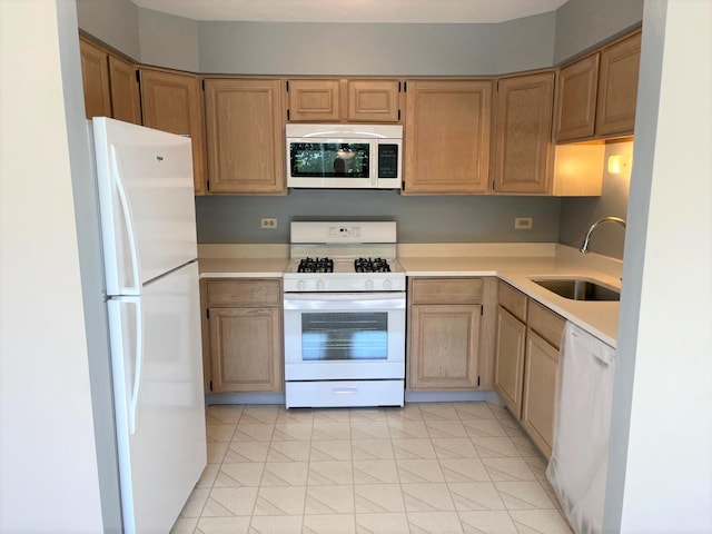 kitchen featuring a sink, light countertops, and white appliances