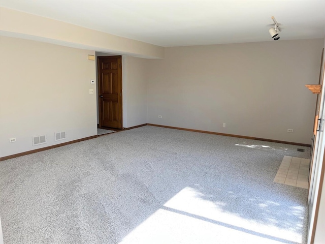carpeted spare room with baseboards and visible vents
