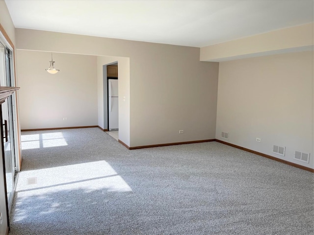 unfurnished room featuring baseboards, visible vents, and carpet