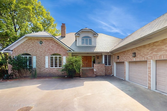 8980 N Enclave Dr, Burr Ridge, IL 60527 - view of front facade with brick siding, a chimney, and asphalt driveway