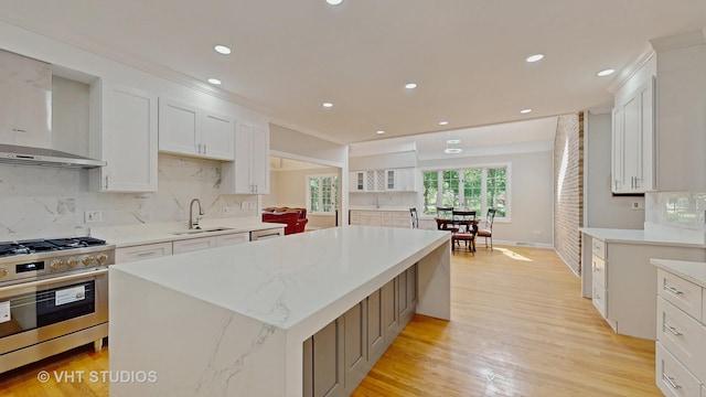 8980 N Enclave Dr, Burr Ridge, IL 60527 - kitchen with stainless steel gas range, a sink, wall chimney exhaust hood, white cabinetry, and a center island