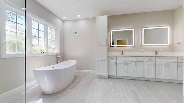 8980 N Enclave Dr, Burr Ridge, IL 60527 - bathroom with double vanity, a freestanding bath, baseboards, and recessed lighting