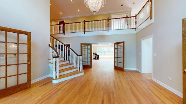 8980 N Enclave Dr, Burr Ridge, IL 60527 - stairway featuring french doors, a high ceiling, a chandelier, and wood finished floors