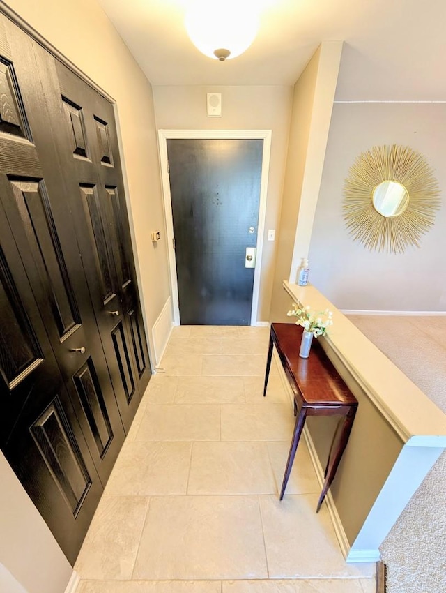 hallway featuring baseboards and light tile patterned floors