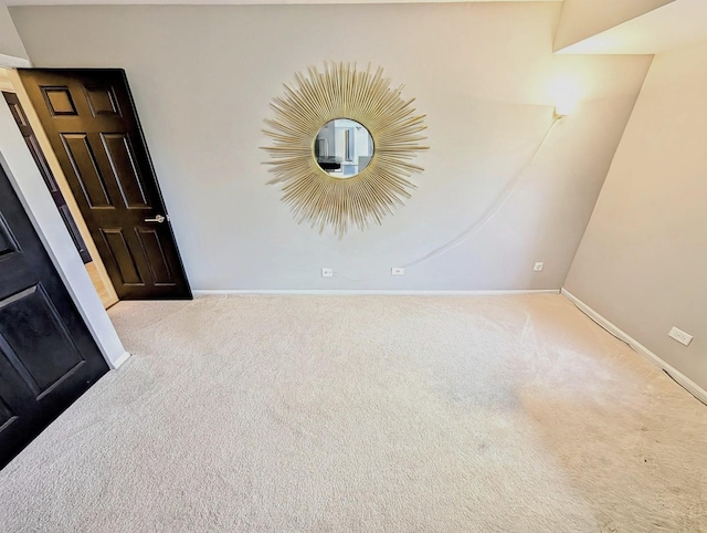 empty room featuring baseboards and carpet