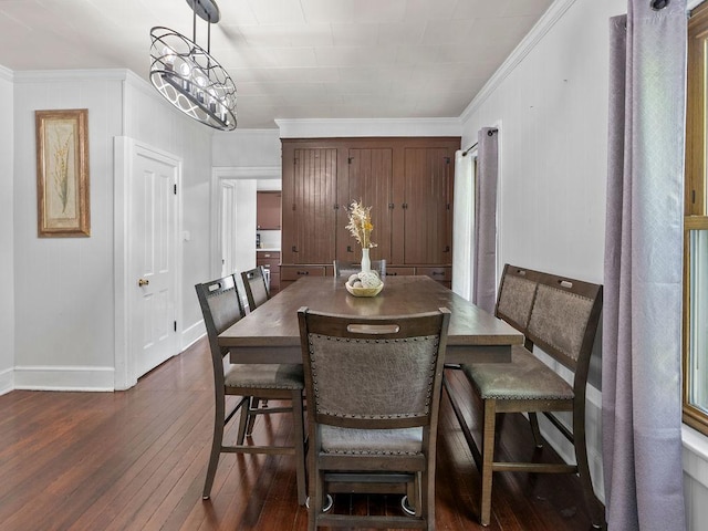 dining space featuring dark wood-style flooring, baseboards, ornamental molding, and a chandelier
