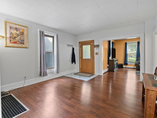 entrance foyer with dark wood-type flooring and baseboards