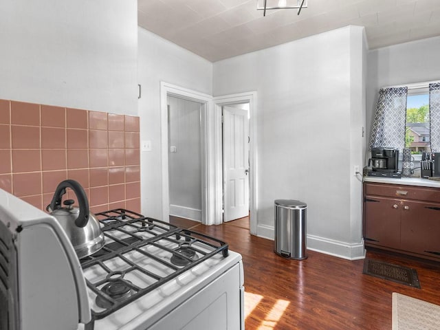 kitchen with range with gas cooktop, dark wood finished floors, and light countertops