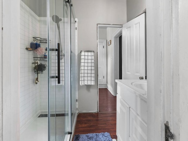 bathroom with a stall shower, vanity, and wood finished floors