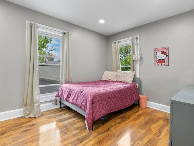 bedroom featuring baseboards, light wood-style flooring, recessed lighting, and access to exterior