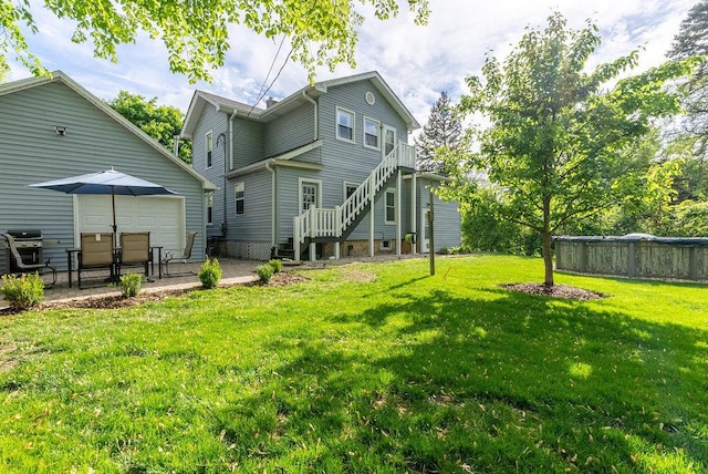 rear view of property featuring a yard, a patio, and stairs