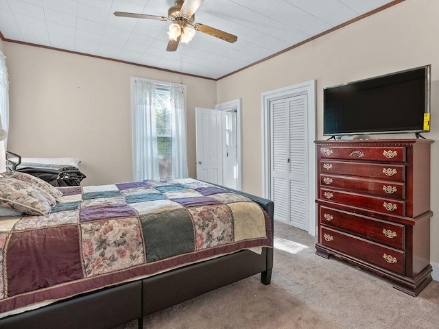 bedroom featuring crown molding, carpet flooring, ceiling fan, and a closet