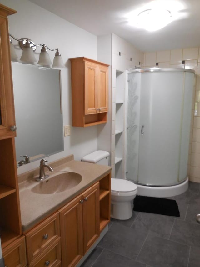 bathroom with vanity, tile patterned floors, a stall shower, and toilet