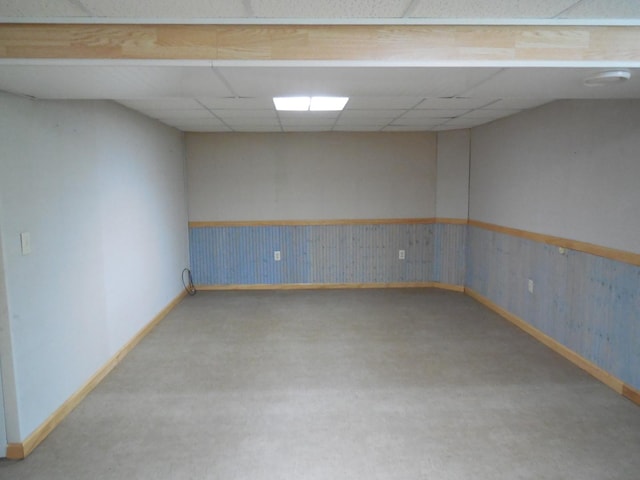 unfurnished room featuring baseboards, carpet flooring, and a drop ceiling