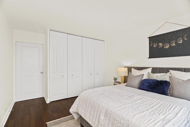 bedroom with wood finished floors, a closet, and baseboards