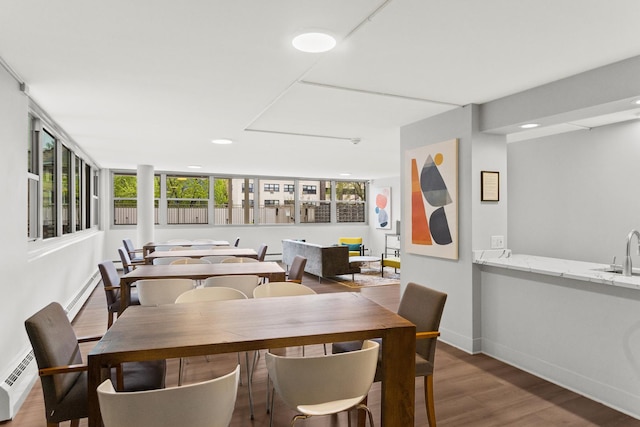 dining space with a baseboard heating unit, wood finished floors, baseboards, and recessed lighting