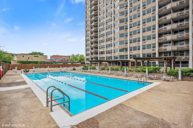 community pool with fence and a patio area