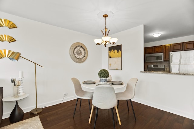dining space featuring a chandelier, dark wood finished floors, and baseboards