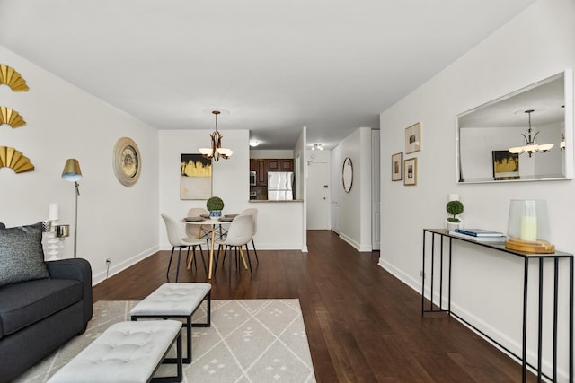 living room featuring a chandelier, wood finished floors, and baseboards