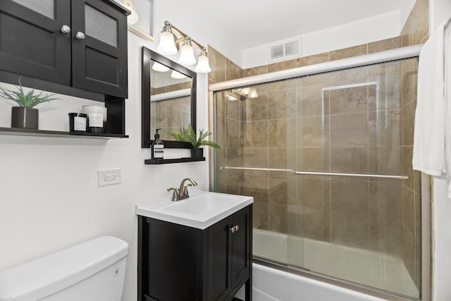 bathroom with toilet, vanity, and enclosed tub / shower combo