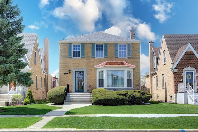 view of front of home with a front yard and brick siding