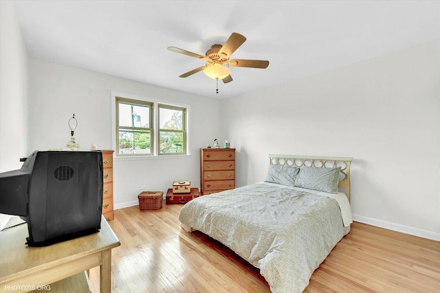 bedroom featuring a ceiling fan, baseboards, and wood finished floors