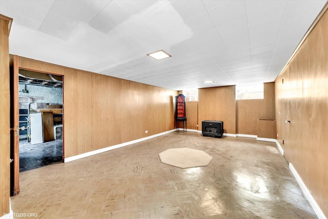 basement with baseboards and wooden walls