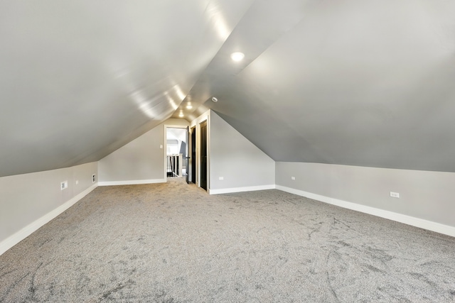 additional living space with vaulted ceiling, carpet, and baseboards
