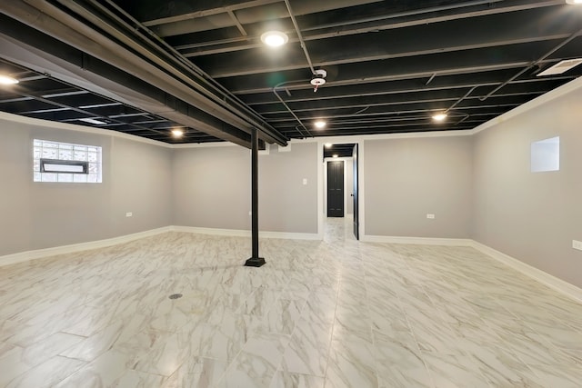 below grade area featuring marble finish floor and baseboards