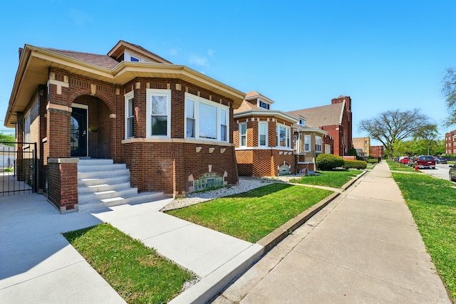 bungalow-style house with brick siding and a front yard
