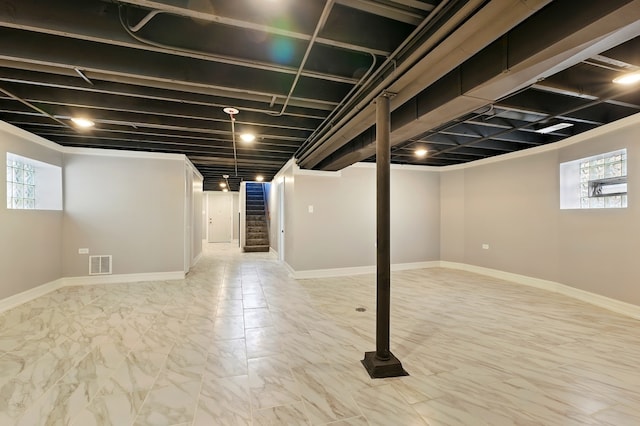 basement with baseboards, stairs, visible vents, and plenty of natural light