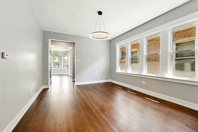 unfurnished dining area with baseboards and dark wood-style floors