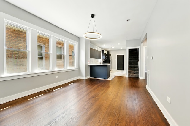 unfurnished living room with visible vents, recessed lighting, stairway, dark wood finished floors, and baseboards