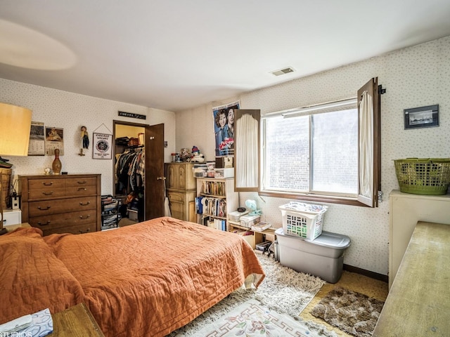 9622 Bianco Ter Unit D, Des Plaines, IL 60016 - bedroom with wallpapered walls, a walk in closet, and a closet