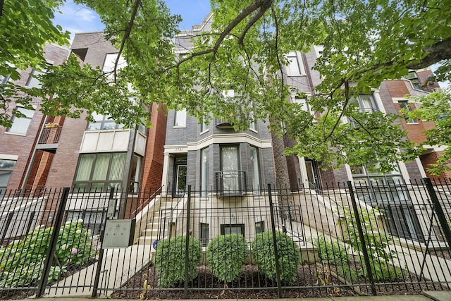view of front of property featuring a fenced front yard and brick siding