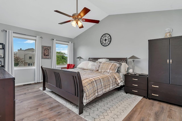 bedroom with light wood-style floors, ceiling fan, and vaulted ceiling