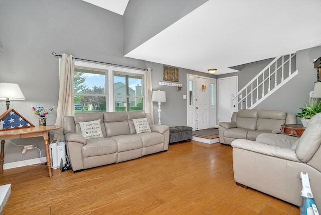 living area featuring stairway, wood finished floors, and baseboards