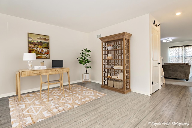 office space featuring baseboards, wood finished floors, and visible vents